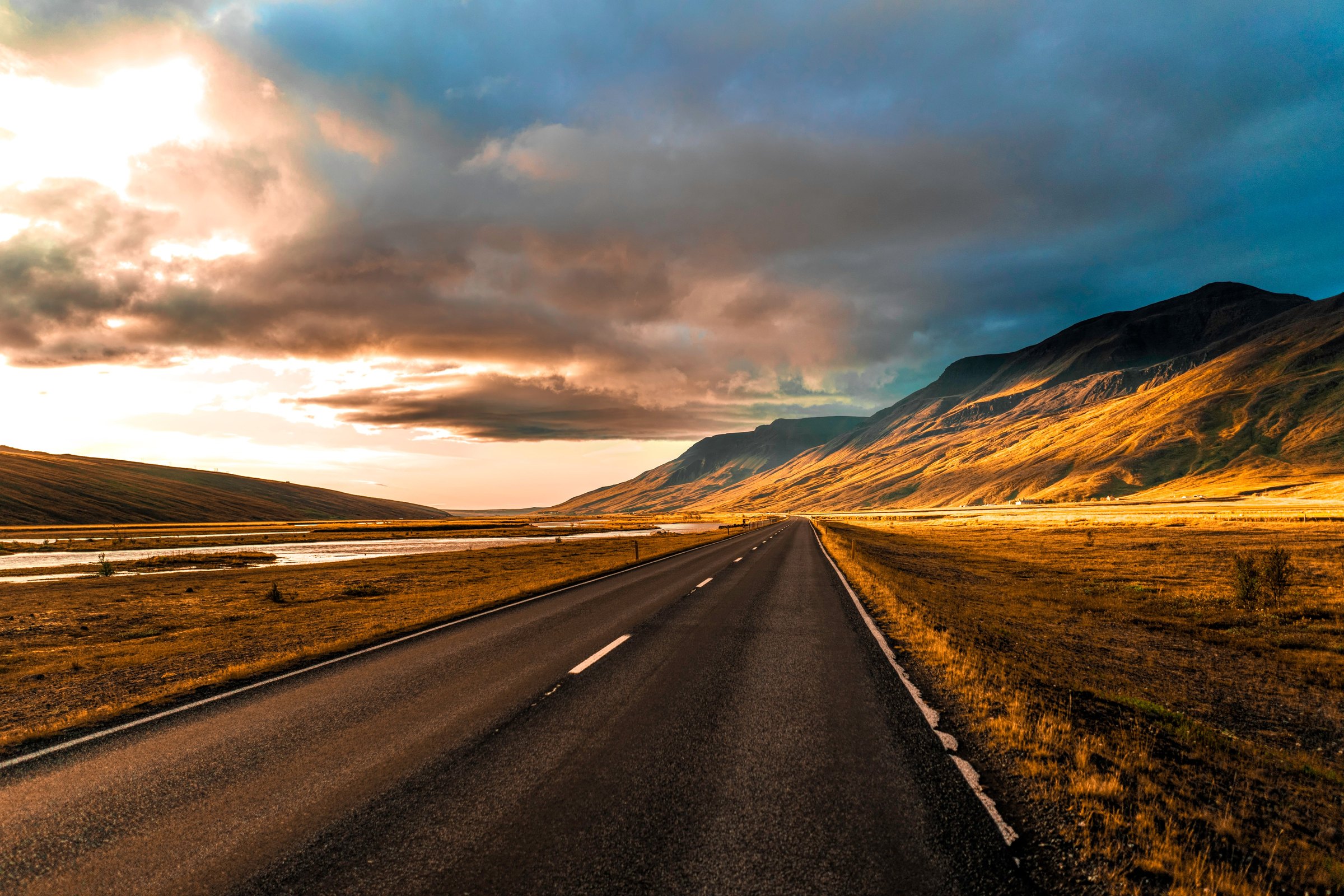Empty road running into a mountain valley at sunrise