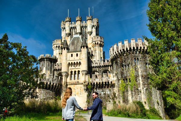 pareja frente al castillo de Butrón en el País Vasco